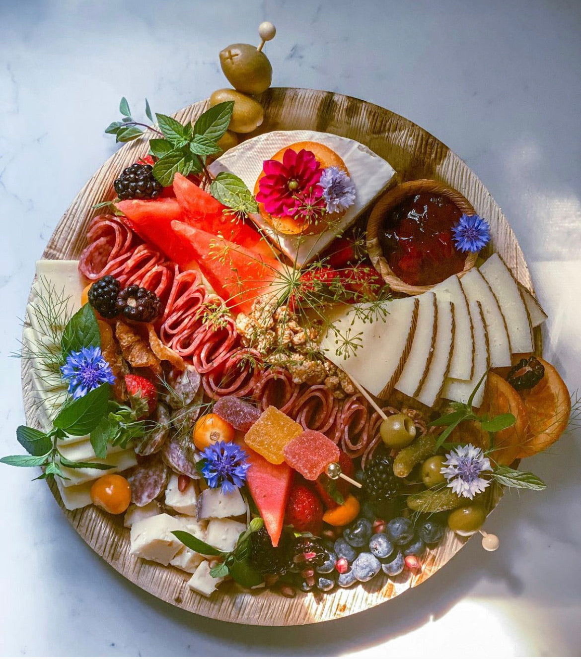 9 inch round verterra palm plate with charcuterie cheese, charcuterie meats, and fruit